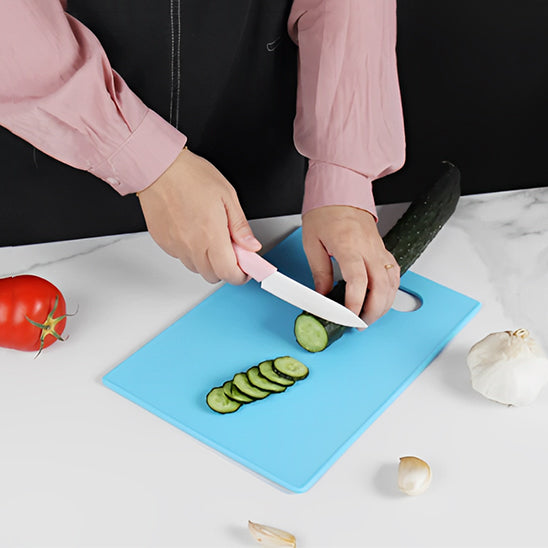 planche-a-decouper-bleu-avec-personne-qui-coupe-un-cocombre-sur-un-comptoir