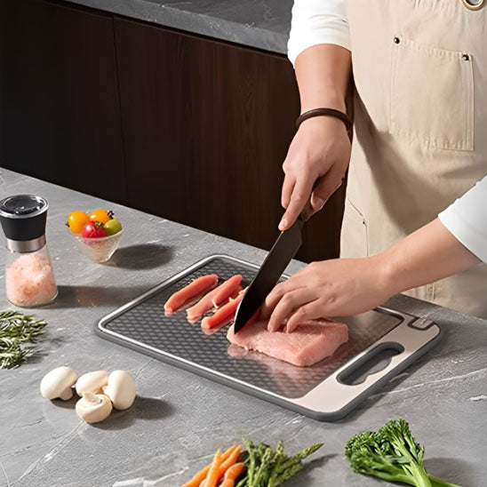 planche-a-decouper-personne-qui-decoupe-du-porc-avec-des-legumes-autour