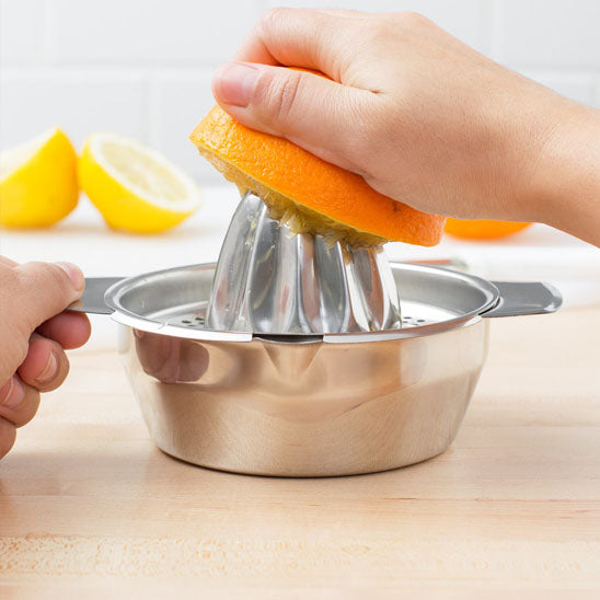 presse-agrume-personne-qui-presse-un-orange-sur-la-table