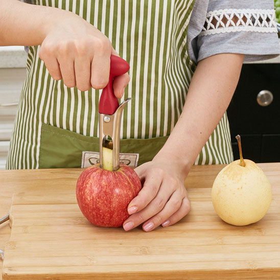 vide-pomme-personne-qui-enleve-le-noyau-d-une-pomme-sur-une-planche-a-decouper